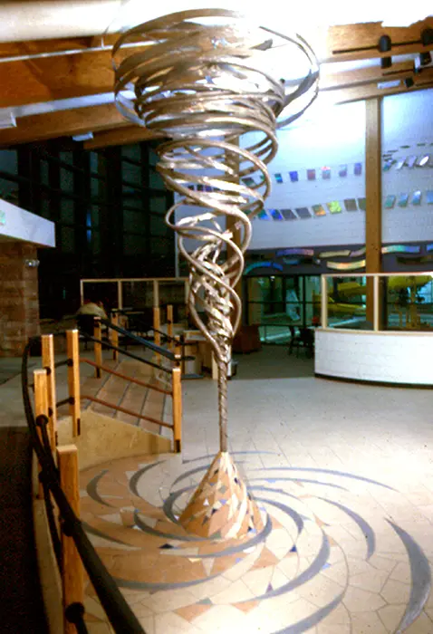 A sculpture of a spiral in the middle of a room.