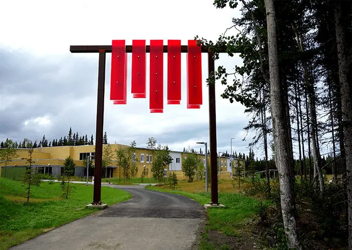 A red sign hanging from the side of a pole.