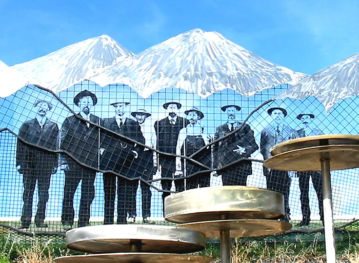 A group of men standing in front of a mountain.