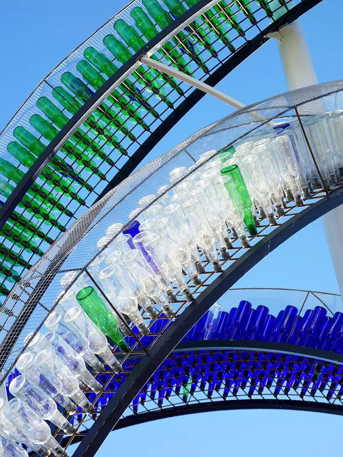 A close up of many bottles on the side of a roller coaster.