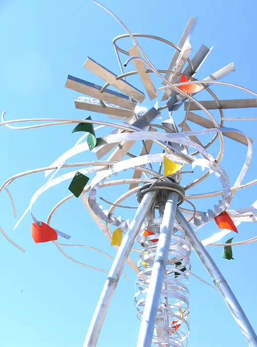 A ferris wheel with many colorful flags on it.