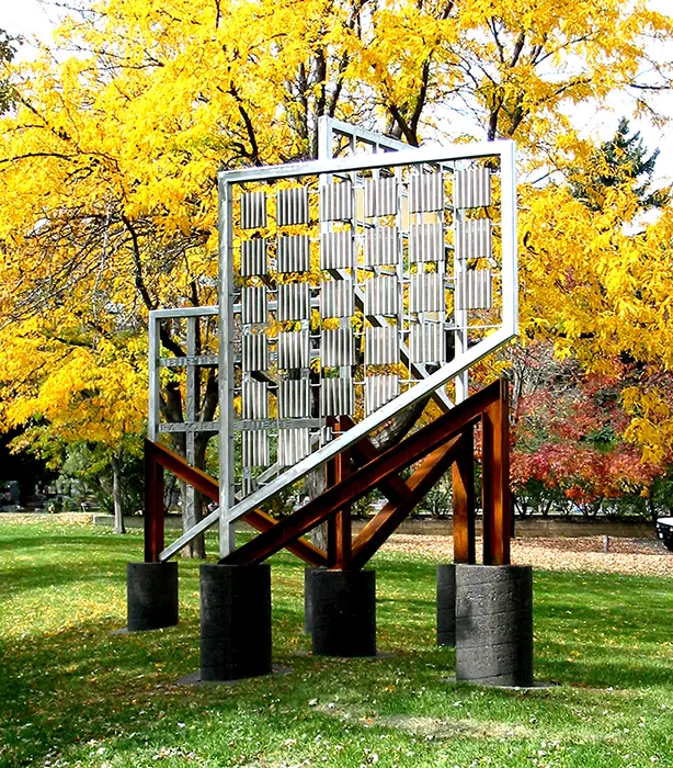 A sculpture of a ladder in the grass.