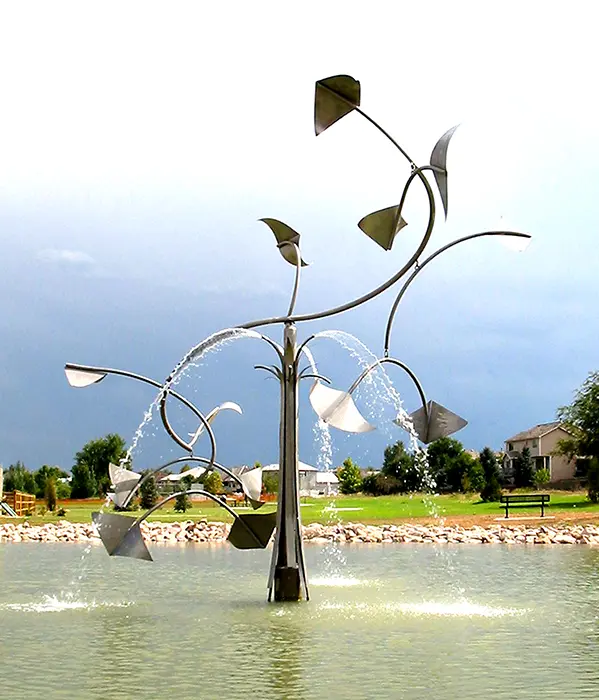 A fountain with leaves and water splashing out of it.